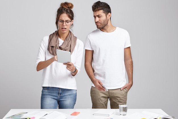 Young coworkers standing near desk