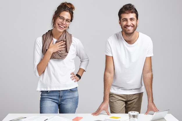 Free photo young coworkers standing near desk