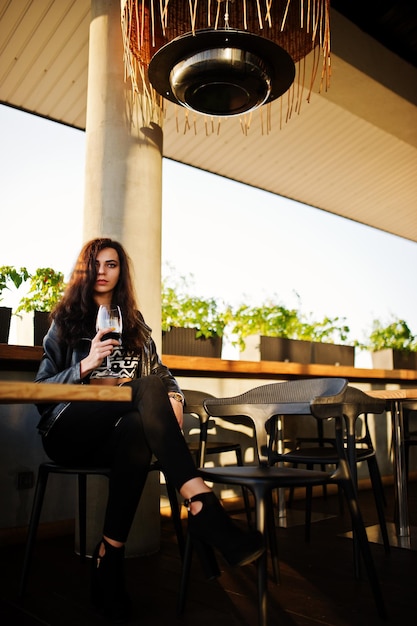 Free Photo young curly woman enjoying her wine in a bar