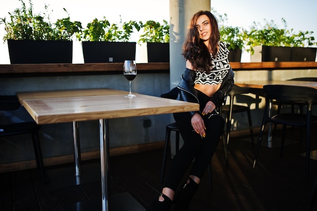 Free Photo young curly woman enjoying her wine in a bar