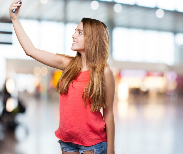 young cute woman taking a selfie on white background