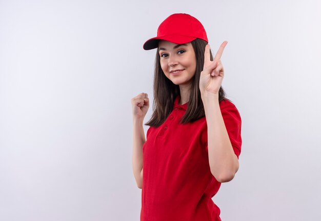 Young delivery girl wearing red t-shirt in red cap showing viva gesture on isolated white background