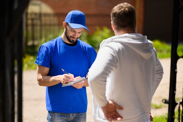 Young delivery man signing for shipment