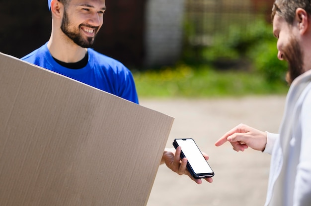 Free Photo young delivery man waiting for customer to confirm shipment