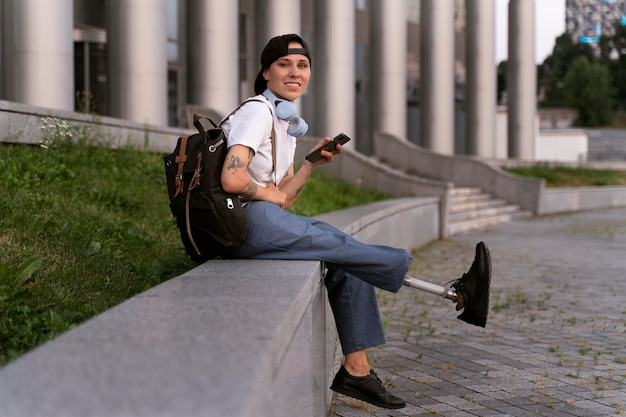 Young disabled person with prosthetic leg outdoors