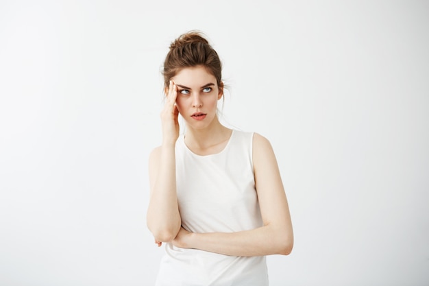 Young displeased tired bored woman holding hand on temple