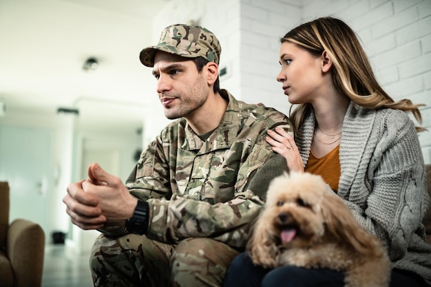 Free Photo young distraught military couple with a dog at home woman is consoling her husband while he is about to leave for deployment