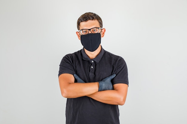 Free photo young doctor in black polo shirt crossing arms and looking at camera and looking confident