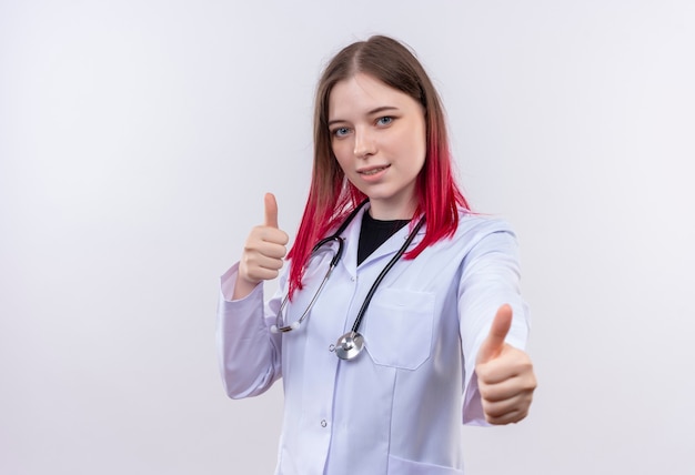  young doctor woman wearing stethoscope medical robe her thumbs up on isolated white wall