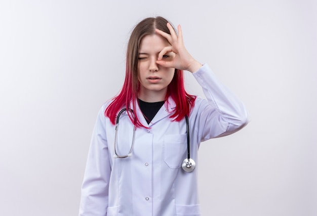  young doctor woman wearing stethoscope medical robe showing look gesture on isolated white wall