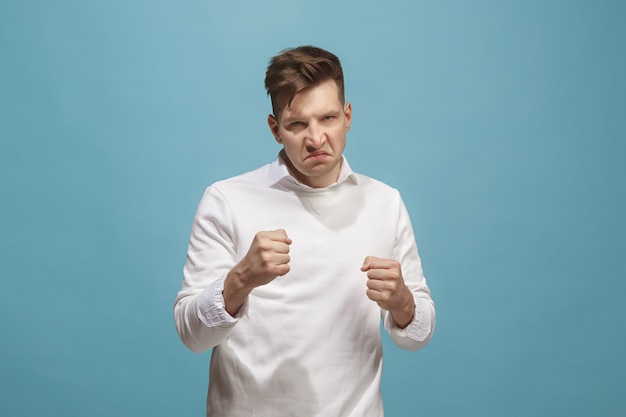 Free photo the young emotional angry man screaming on studio background