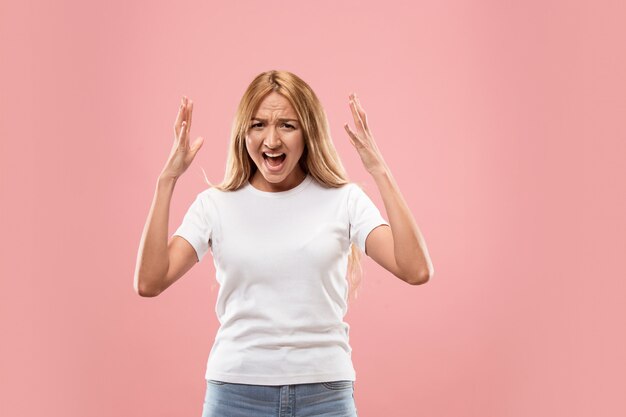 The young emotional angry woman screaming on studio