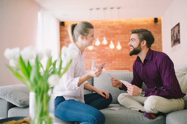 Free photo young emotional couple playing cards