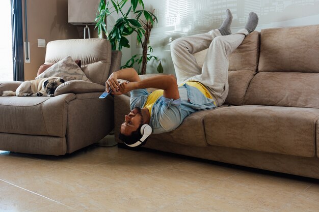 Young emotional man chatting online on the phone at home