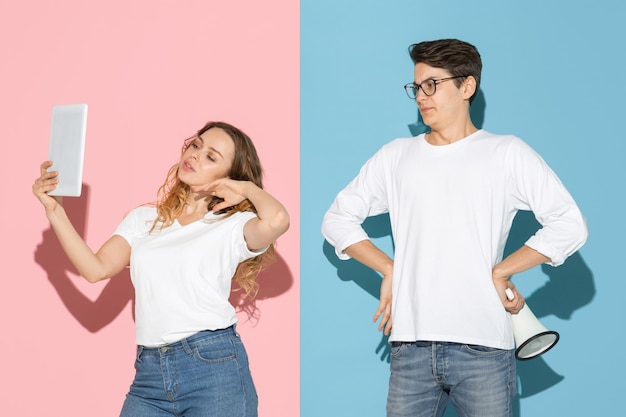 Free Photo young emotional man and woman on pink and blue