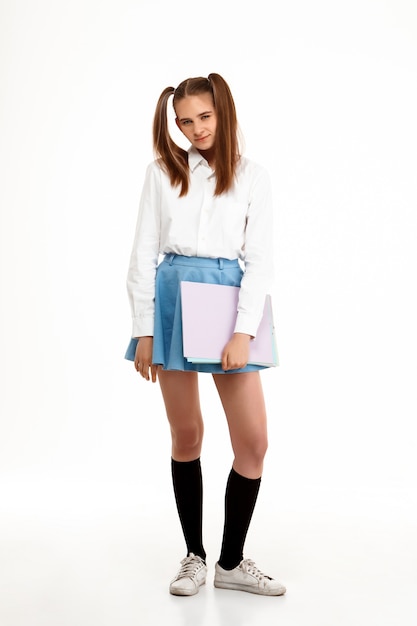 Young emotional pretty girl in uniform posing over white wall