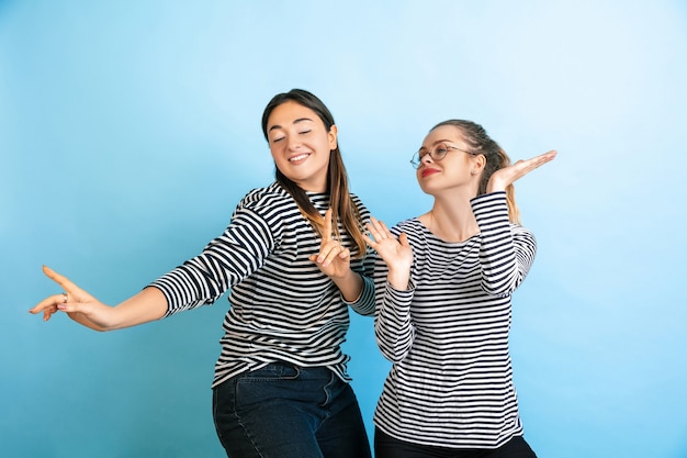 Free photo young emotional women isolated on gradient blue studio wall