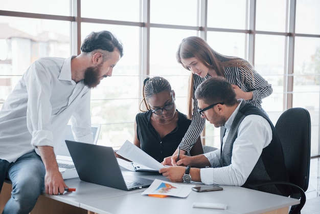 Young employees sitting in the office at the table and using a laptop