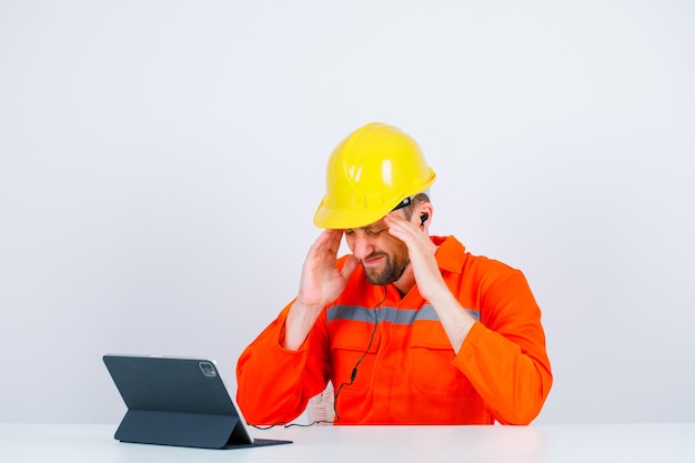 Free Photo young engineer is suffering from headache is putting hands on temples on white background