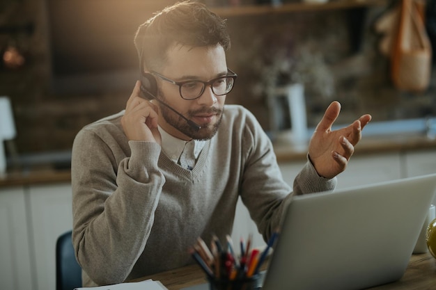 Young entrepreneur having conference call over a computer while working at home