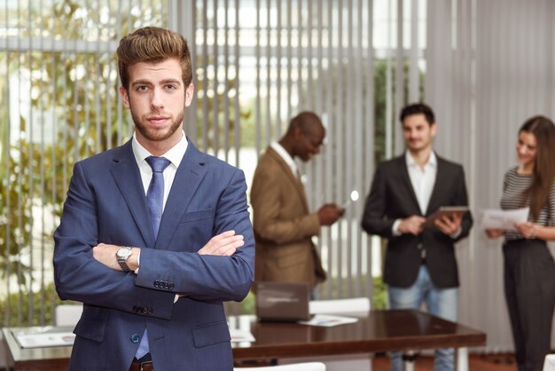 Young executive with crossed arms in the workplace