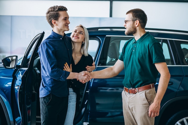 Young family buying a car in a car showroom