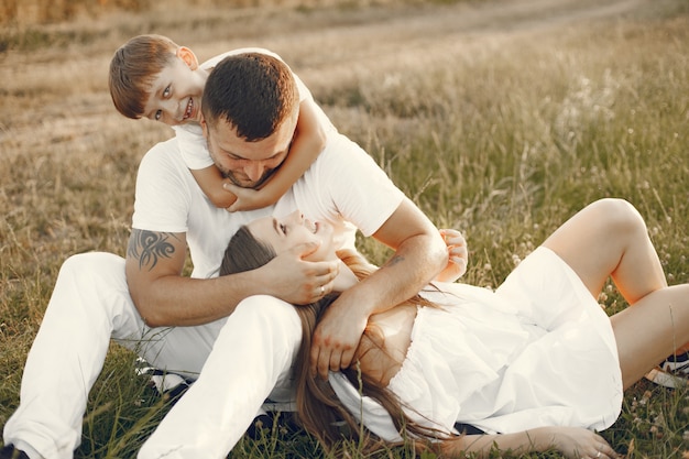 Free Photo young family sitting on a grass together in a sunny day.