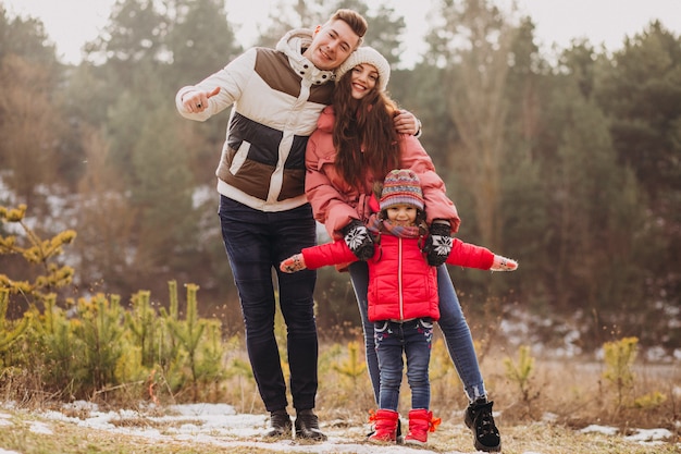 Young family together walking in forest at winter time