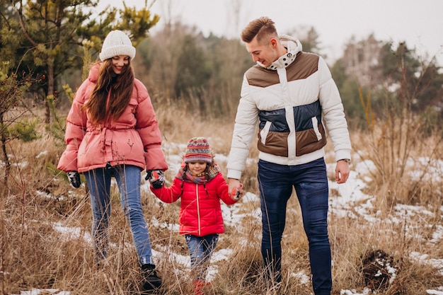 Young family together walking in forest at winter time