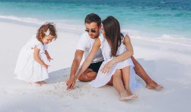 Young family with little daugher on a vacation by the ocean