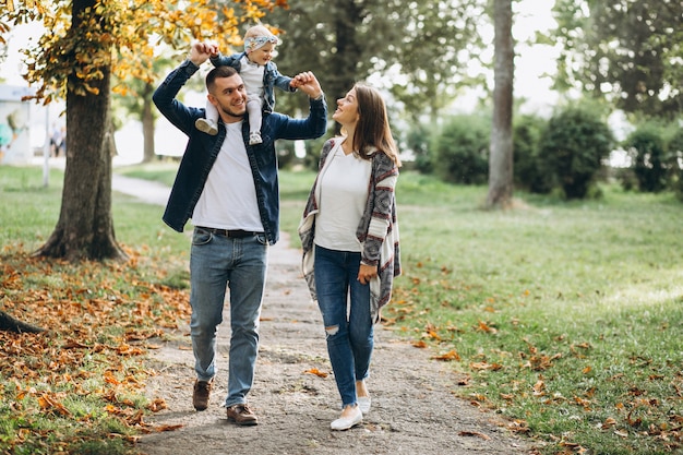 Young family with their small daughter in autumn park