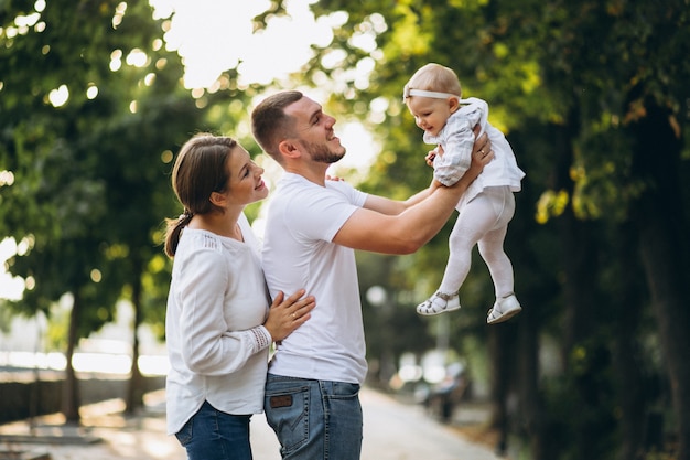 Young family with their small daughter in autumn park