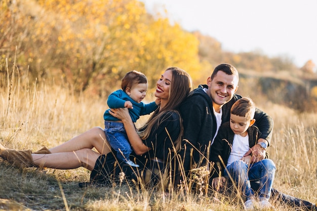 Young family with two sons together sitting in park