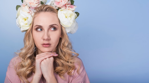 Free photo young fearful blond lady with beautiful flower wreath