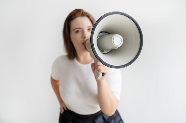 Young female activist talking about her ideas in megaphone