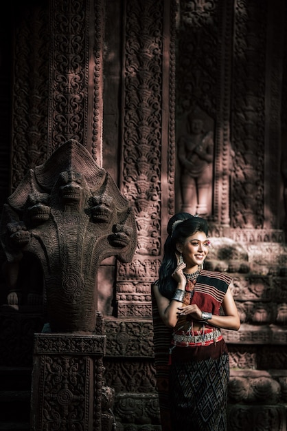 Free photo young female actress wearing beautiful ancient costumes, in ancient monuments, dramatic style. perform on legend love popular story, thai isan folktale called 