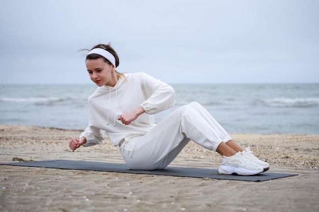 Free photo young female athlete laying on mat and doing exercises high quality photo