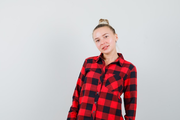 Free photo young female in checked shirt looking confident , front view.