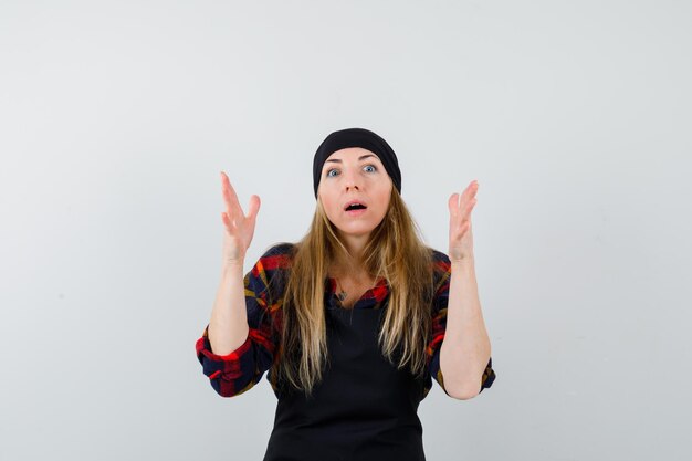 Young female cook in a black apron being scared