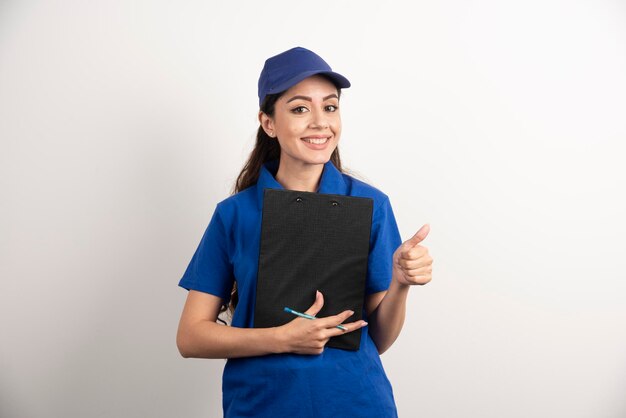 Young female courier in blue scrubs holding a clipboard. High quality photo