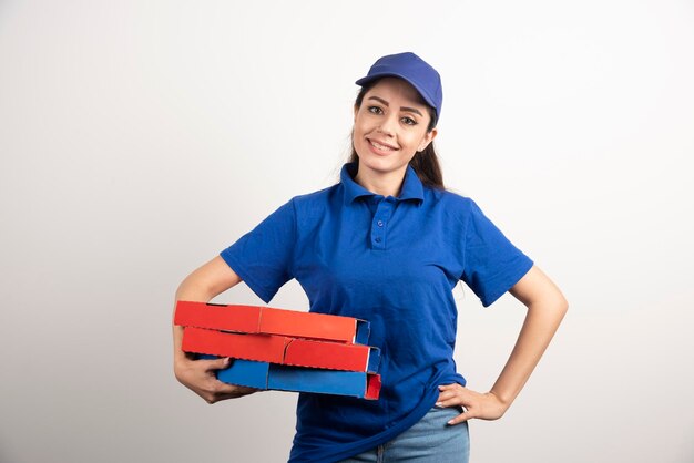 Young female courier with cardboard of pizza and clipboard