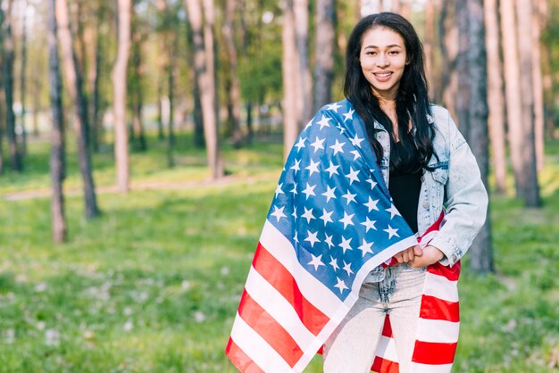 Young female covered with flag of USA