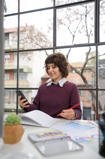 Young female designer checking her smartphone