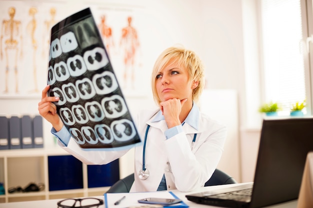 Free photo young female doctor studying x-ray image