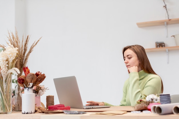 Young female florist working on her laptop