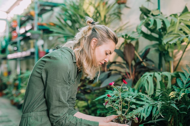 Young female gardener taking care of plants