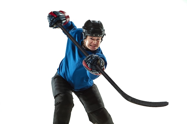 Free photo young female hockey player with the stick on ice court and white wall