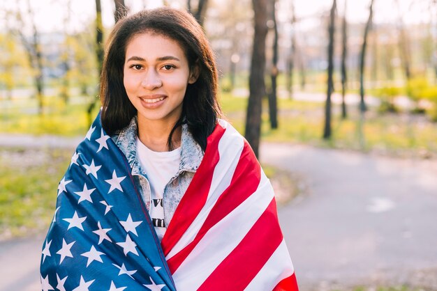 Young female holding American flag on sunny day