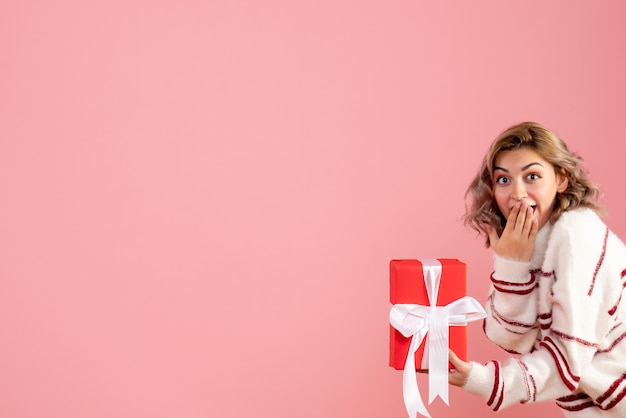 young female holding present on pink