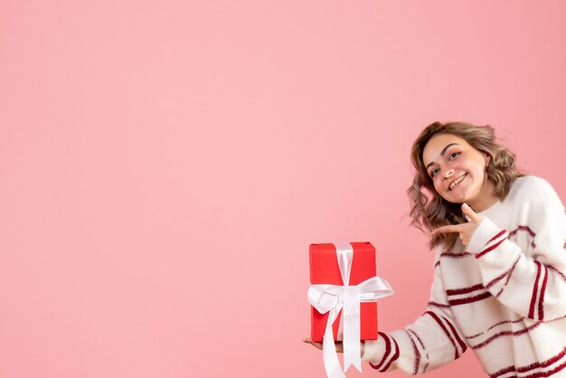 young female holding present on pink